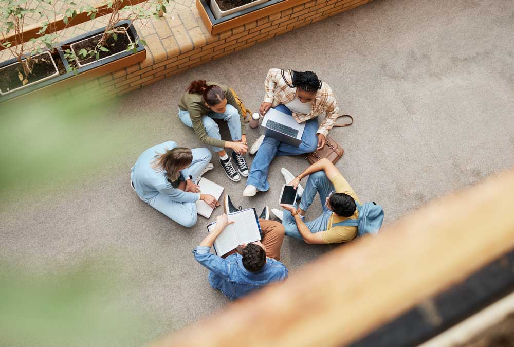 Study, laptop and group of students on floor in project, research or planning, brainstorming and teamwork. Notebook, education and top of university student, friends or people collaboration in school